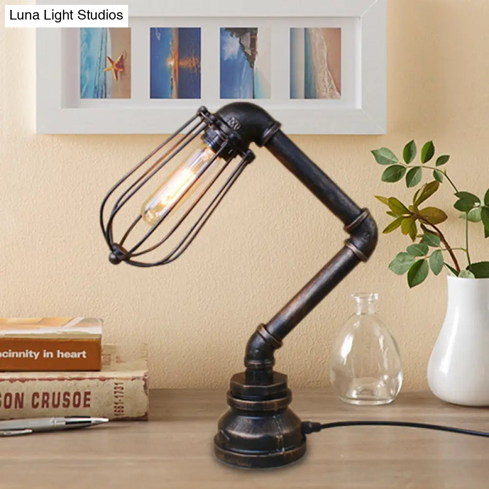 Industrial Style Metal Table Lamp With Bulb Cage Shade & Water Pipe In Aged Bronze