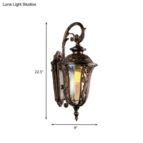 Bronze Metal Outdoor Wall Sconce With Curved Arm Amber Glass Shade - 1-Light Lamp
