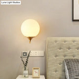 Minimalist Gold Sphere Bedside Wall Sconce - 1-Light Milk Glass Mounted Light With Right Angle Arm