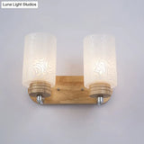Modern 2-Headed White Glass Cylinder Wall Sconce With Wood Mount And Rose Pattern