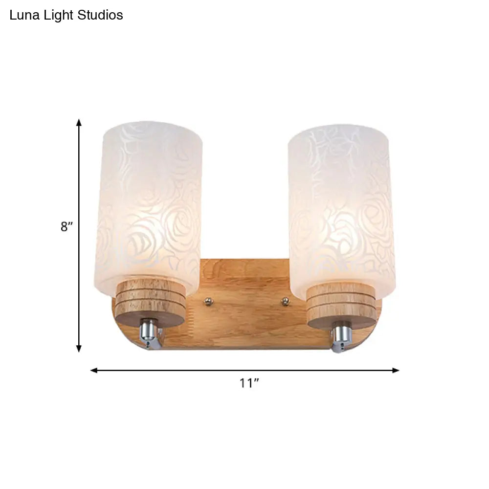 Modern 2-Headed White Glass Cylinder Wall Sconce With Wood Mount And Rose Pattern