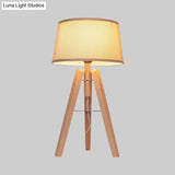 Modernist Fabric Tapered Desk Lamp With Wood Tripod - 1 Bulb Night Table Light In Brown/Beige
