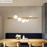 Nordic Wood Island Pendant With Globe Glass Light For Dining Room In Beige