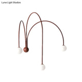 Red Curved Arm Sconce With Minimalist Design And Metal Finish For Bedside Lighting