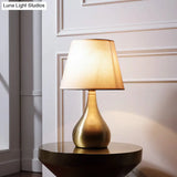 Sleek Metallic Urn-Shape Table Light - Simplicity 1-Light Brass Finish Lamp With Barrel Fabric Shade